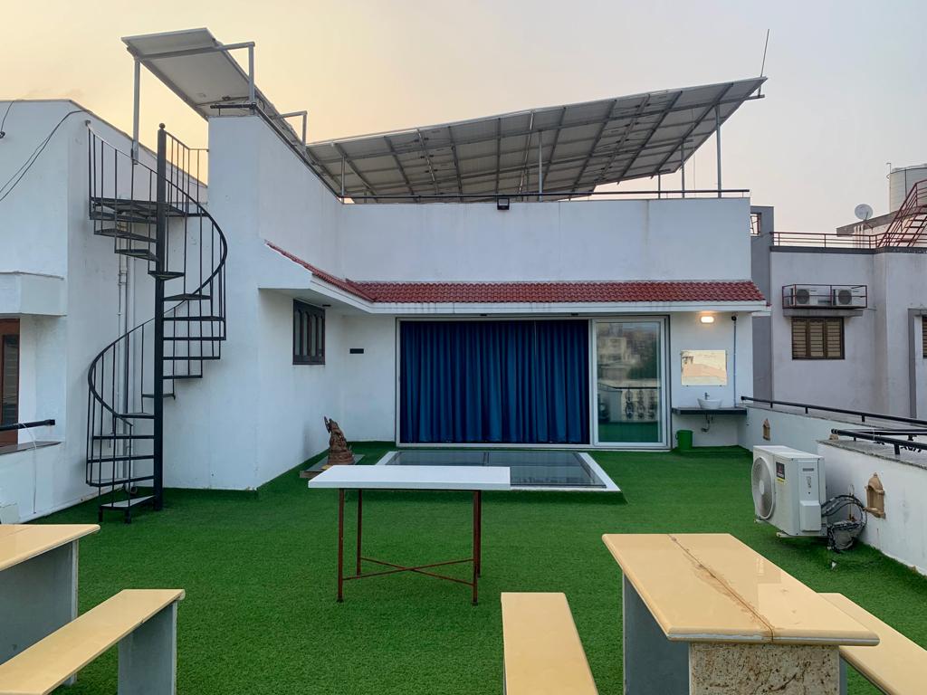Open bungalow terrace with seating and rooftop solar panels