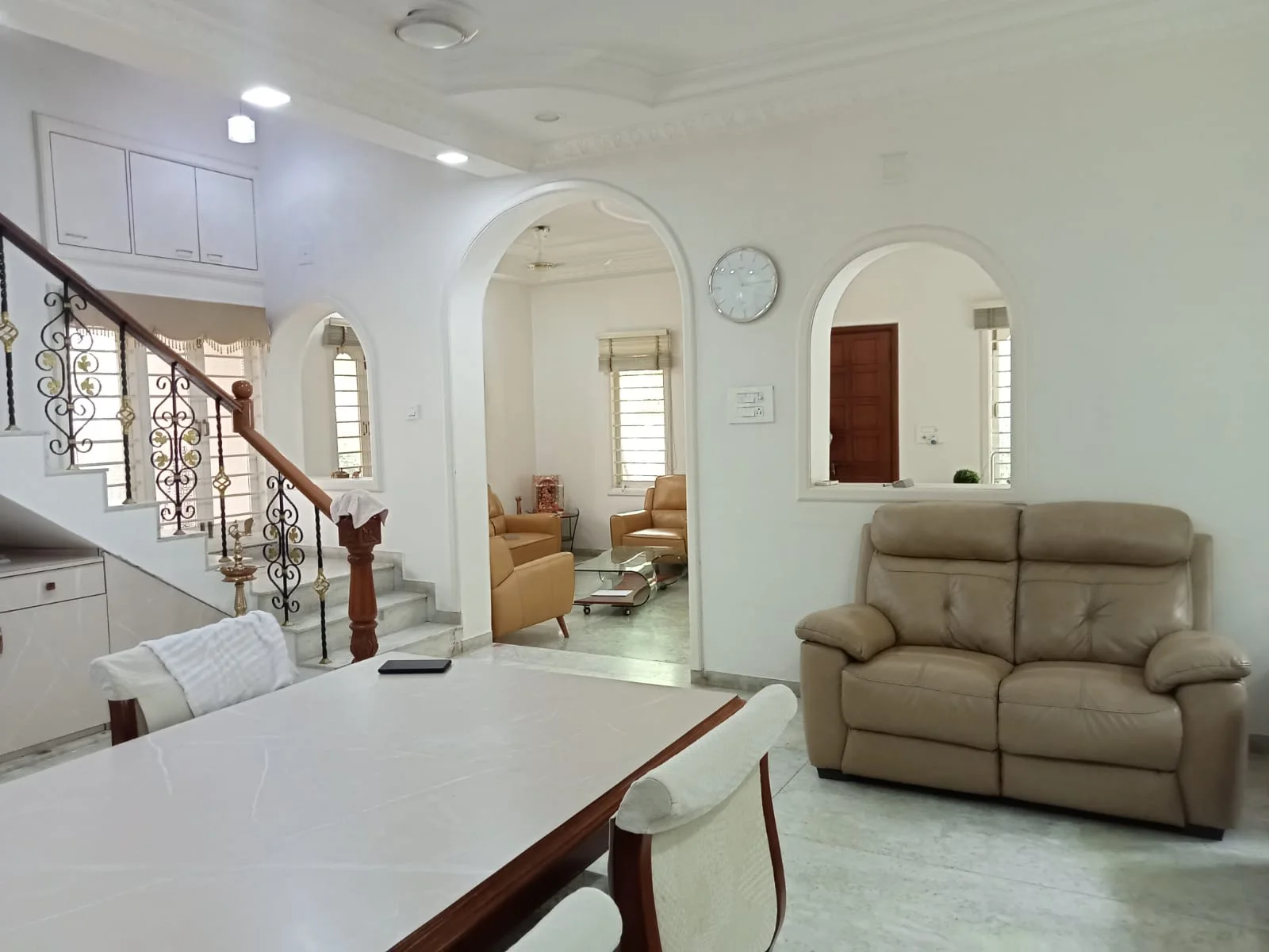 Spacious central lounge with arched interiors and staircase